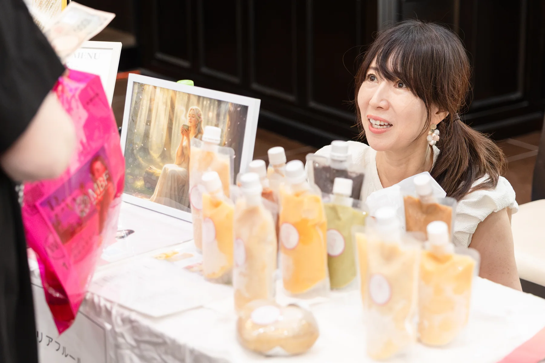 出展ブースで来場者と会話する出展者
